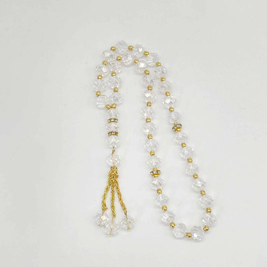prayer beads with clear and gold beads on a white background