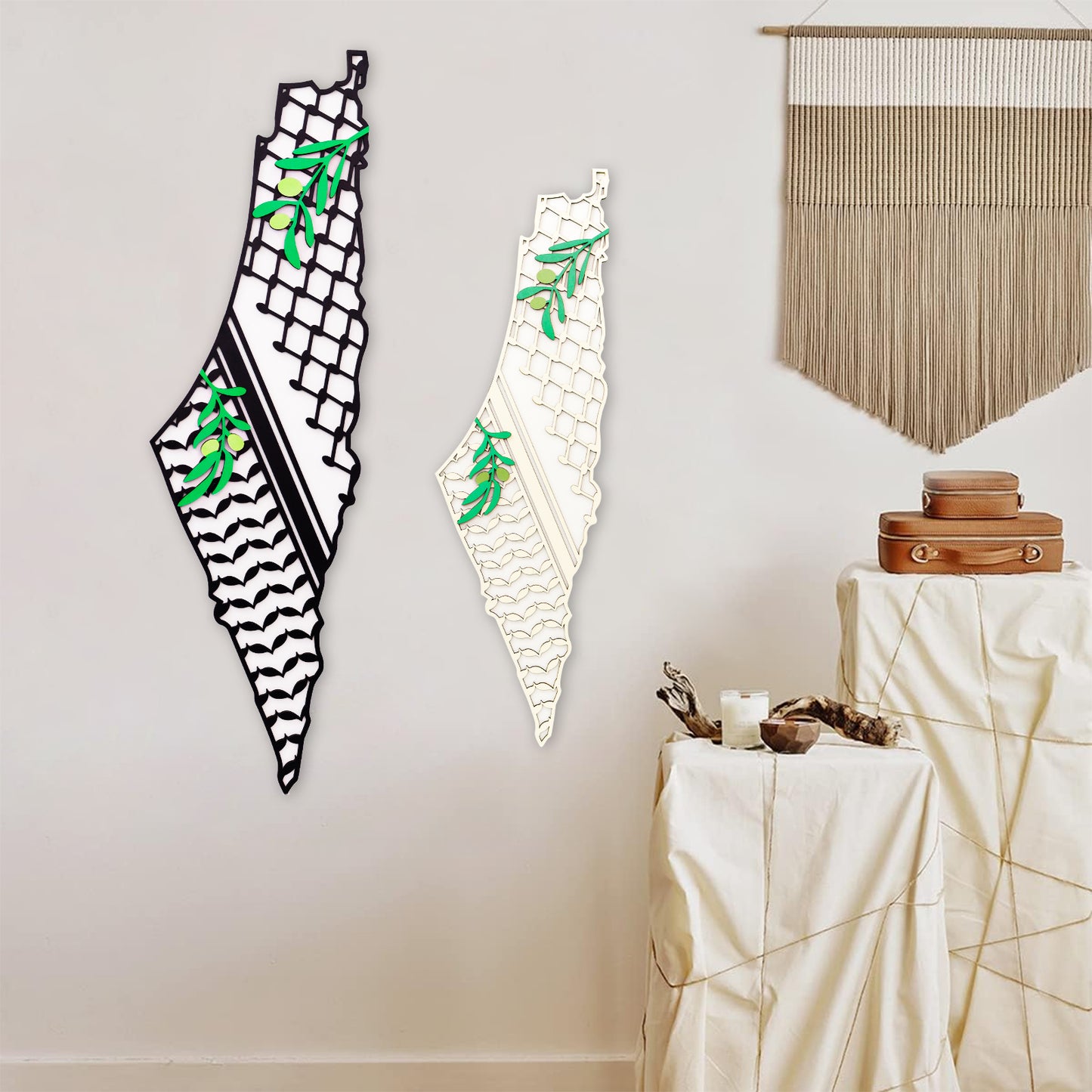 Two decorative wooden palestine wall art pieces on a plain wall with a table and decorative items in the foreground.