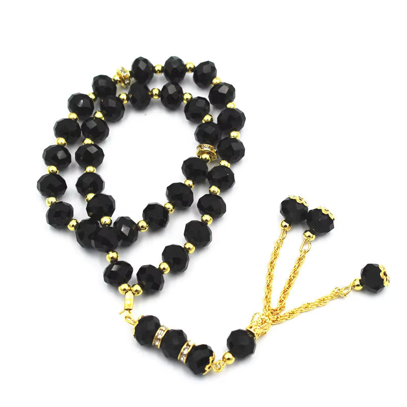 Black prayer beads with gold accents on a white background