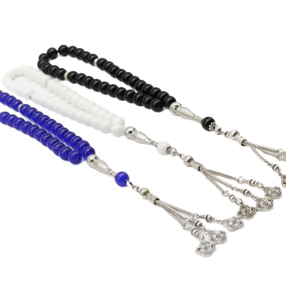 prayer beads (masbaha) with blue, black, and white beads on a white background