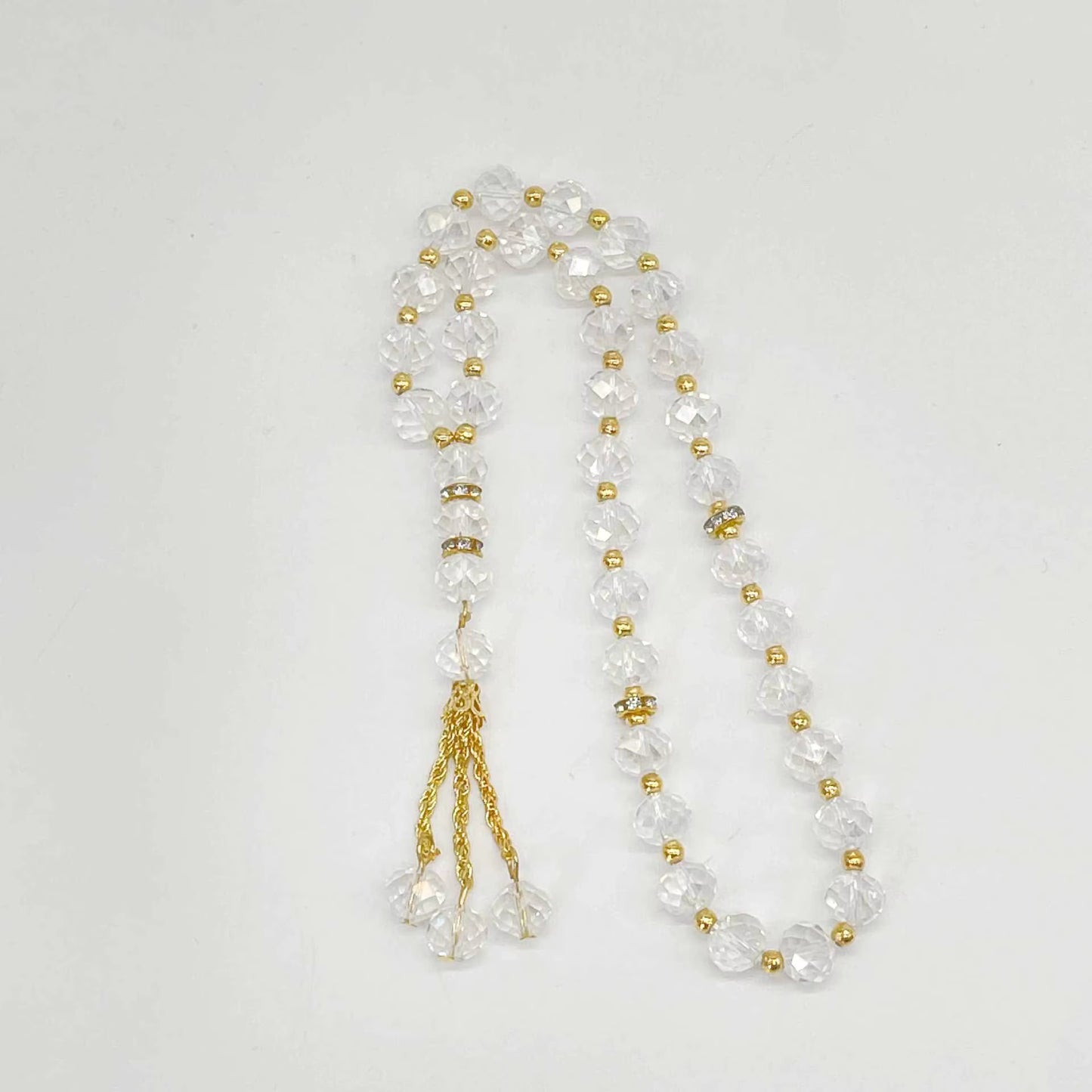 prayer beads with clear and gold beads on a white background