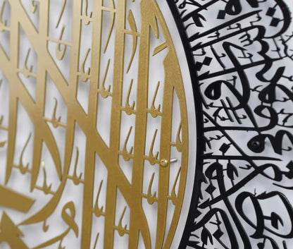 Close-up of a decorative wall panel with gold and black Arabic calligraphy.